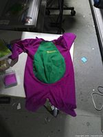Full view of Barney kids costume laid flat showing purple body and green belly