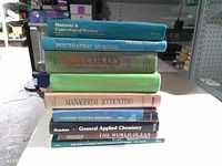 Front view of stacked textbooks showing spines and titles