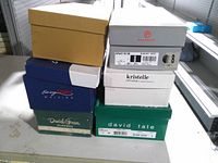 Stack of six shoe boxes showing brands Easy Spirit Walking, Daniel Green Slippers, Naturalizer (tan box), Rockport, Kristelle, David Tate