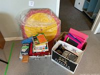 Lot overview showing crokinole board, game stack, office supply box