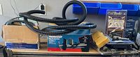 Overview showing boxed bench vise, coiled hose, boxed hose kit and assorted packaged tools