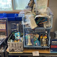 Wide shot of two blue baskets filled with packaged and loose hardware pieces