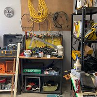 Overall view showing workbench, pegboard, extension cord, tools and shelving