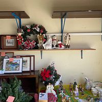 Shelving with nutcracker, wreath, angel, snowman, poinsettia arrangement, nativity figurines visible