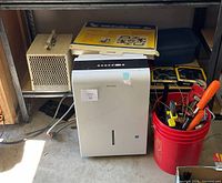 Overall lot showing Danby dehumidifier, hand tools in red bucket, boxed item on top, cords and clamps nearby