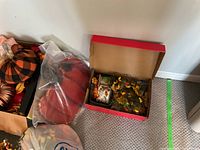 Box of red plush pumpkins, flower picks and decor