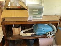 Shelf with canister vacuum, hose, attachments, boxed parts, plastic drawer
