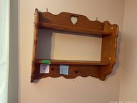 Heart-cut two-tier pine wall shelf on wall