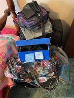 Stack of suitcase, duffel, crossbody and heating pad box