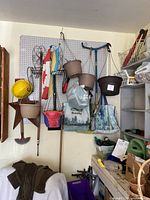 Overall view of hanging planters, flags, hand tools, star decor, watering can and baskets