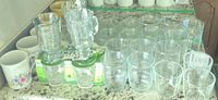 Countertop view of clear tumblers, mugs, pitchers