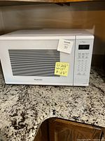 Front view of Panasonic white countertop microwave on granite counter