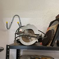 Circular saw on shelf with wall hook visible