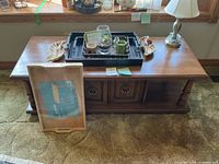 Full view of coffee table with lamp, trays, decor pieces, bed tray leaning against front