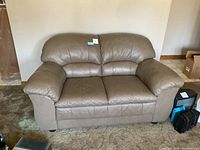 Front view of taupe leather loveseat