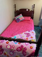 Overall view of twin bed with frame, mattress, bedding