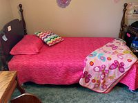 Full view of twin bed with frame, mattress and bedding