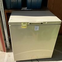 Front view of cream Woods chest freezer with lid closed