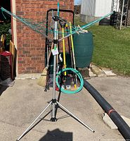 Tripod rotary clothesline with garden hose attached