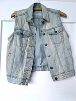 front view of GAP denim vest hanging on hanger