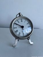 Front view of silver-tone desk clock on stand