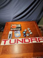 Overall view of lot showing Tundra decal, lug nuts pack, Plus box, tape roll, center caps
