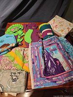Overview of lot showing wall hangings, blankets, fabric panels, sheet set, box