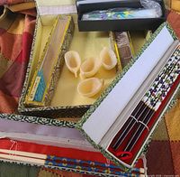 Open gift box showing fans, candle box, and teacups