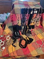 Full lot on plaid cloth showing jewelry pieces and black velvet display