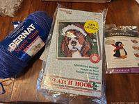 Front view of Bernat yarn skein, WonderArt latch hook kit, Dimensions penguin kit