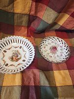 Both decorative bowls resting on quilt, showing size and designs