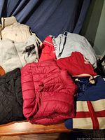 Assortment of jackets, vest and hoodies laid out