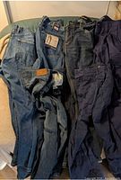 Group of five pairs blue and navy pants laid out