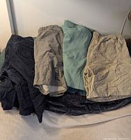 Four pairs of shorts laid out: navy, grey, sage green, beige