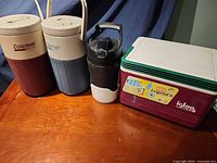 Group shot of two Coleman jugs, Under Armour jug, Igloo Legend 6 cooler