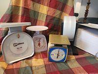 Group shot of three scales, packing tape roll, stack of envelopes