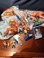 Overview of entire lot: bedding, alarm clock, ornament, figures