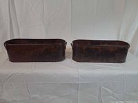 Both copper planters side-by-side, showing overall form, relief decoration and patina