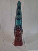 Front view of wood bust showing face and headdress colors