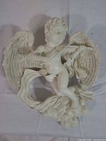 Front view of ivory resin cherub wall sculpture