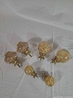All six acrylic and gold curtain rod finials displayed