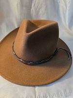 Overall view of brown felt fedora with leather beaded band