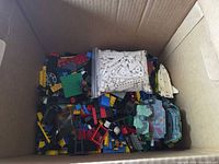 Box of multicolor loose building bricks with bag of white pieces