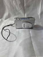 Front view of Olympus Camedia D-550 Zoom camera with wrist strap attached