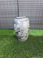 Front view of cast metal vase with cockatoo and floral embossing