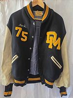 Front view of Skookum varsity jacket showing patches, snap closure, leather sleeves