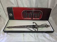 Open United Cutlery box displaying dagger inside with sheath