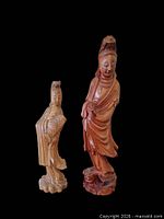 Front view of both wooden Guanyin statues against black background
