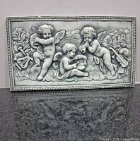 front view of plaster plaque with cherubs