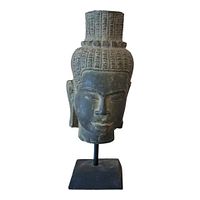 Front view of stone carved Khmer Buddha head on metal stand